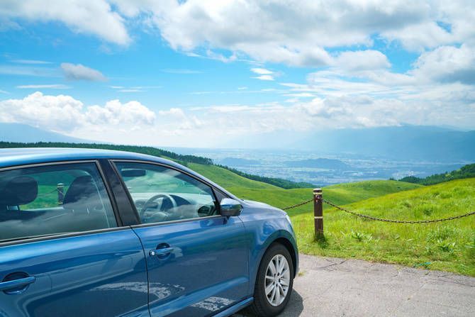 高原の駐車場に青いファミリーカーを止める