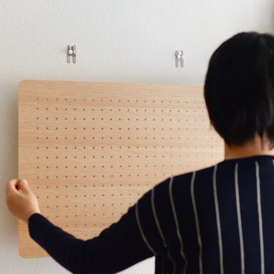 女性がペグボードを設置する様子