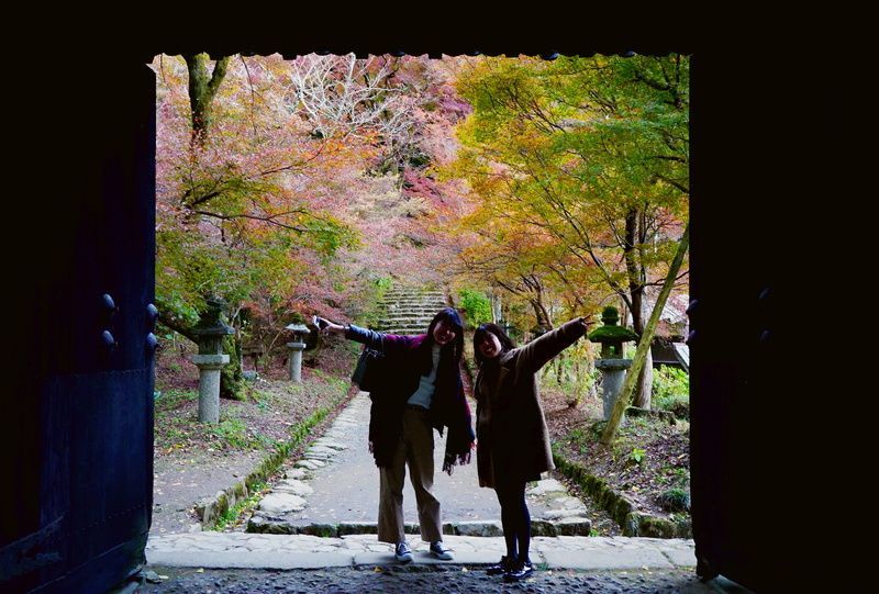 秋月の黒門でポーズをとる女性