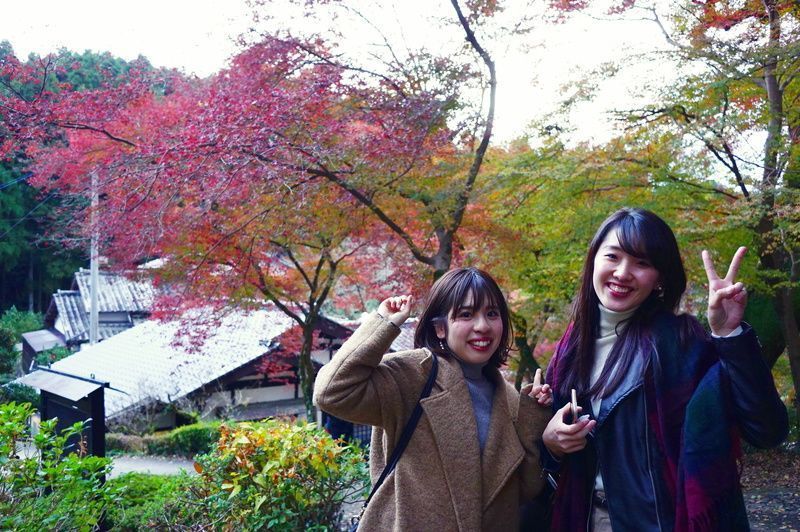 秋月の紅葉を背景に笑顔の女性