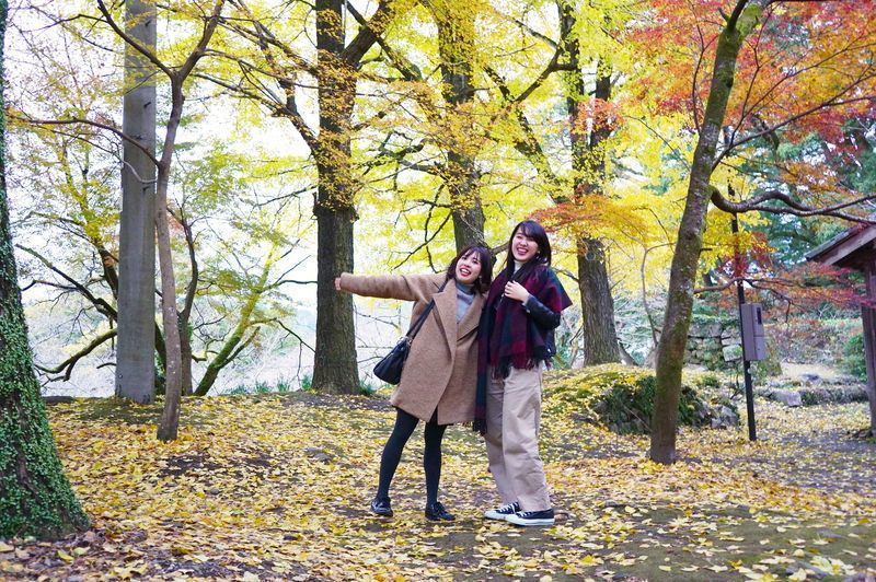 落ち葉のじゅうたんを楽しむ女性